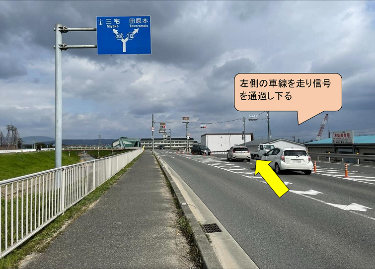 左側の車線を走り信号を通過し下る写真