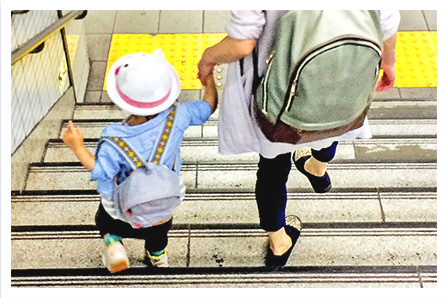 母親と子供が手をつないで階段を降りている画像